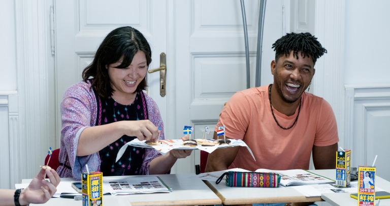 Adult learners share a cultural food activity in a classroom at International House Budapest.